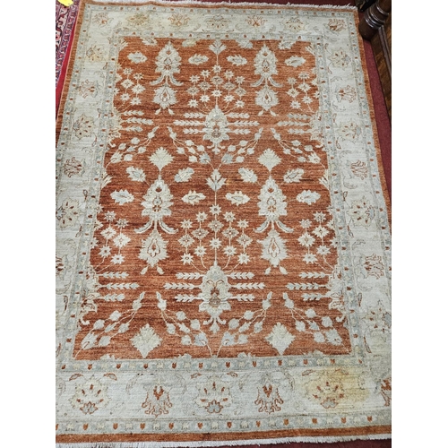 61 - A cream and rust ground Zeigler style wool Carpet. 238 x 178 cm approx.