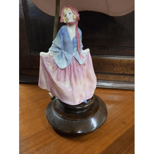 604 - A 19th Century Royal Doulton Figure of a woman on a table lamp base and pink shade. H 47 cm approx.