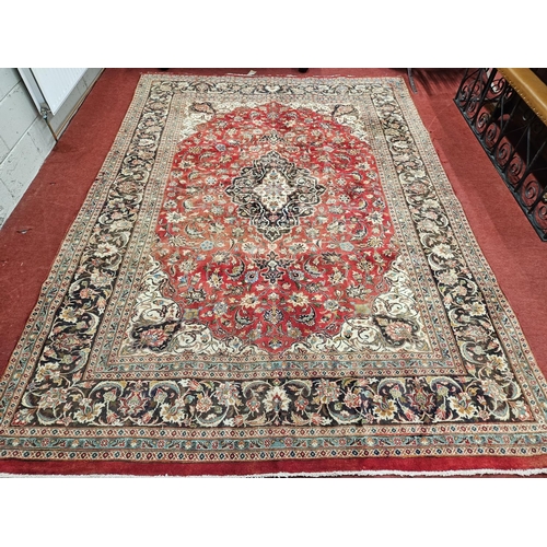 9 - A rich Red ground Iranian Carpet with rich border and a traditional design from the Mashhad region. ... 