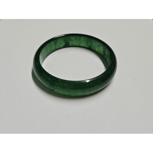 244 - A dark Green Jade Bangle.