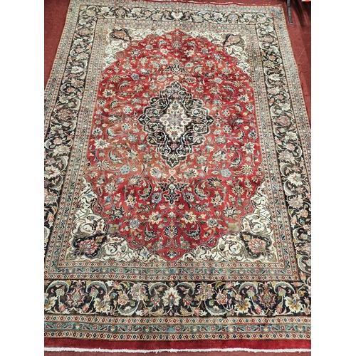 823 - A rich Red ground Iranian Carpet with rich border and a traditional design from the Mashhad region. ... 