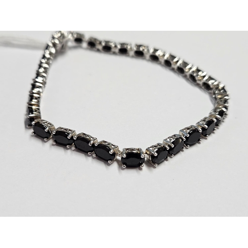 318 - A Silver Bracelet set with a line of Sapphires.