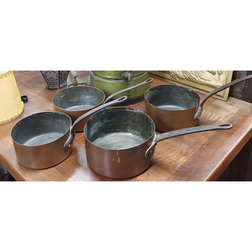 522A - A good graduated set of 19th Century Copper Saucepans with cast iron handles.