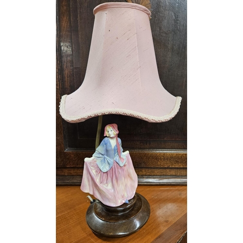 604 - A 19th Century Royal Doulton Figure of a woman on a table lamp base and pink shade. H 47 cm approx.