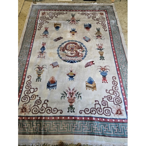 989 - A cream ground Oriental Carpet with Greek key border design. 244 x 345 cm approx.