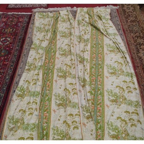 425 - A pair of  Lined Curtains, Green ground depicting Peacocks. 
Peated Top width 66 cm each, length 230... 