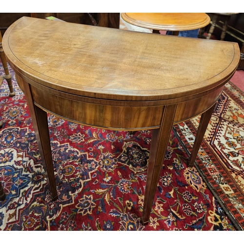 576 - A Regency Mahogany demi lune foldover Card Table on square inlaid supports.
H 73 x 90 x 45 cm approx... 