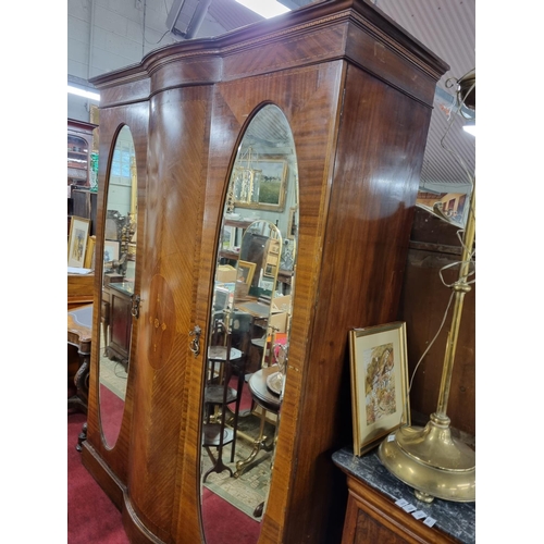 285 - An Edwardian Mahogany Inlaid and veneered two door wardrobe with a bow fronted centre panel flanked ... 