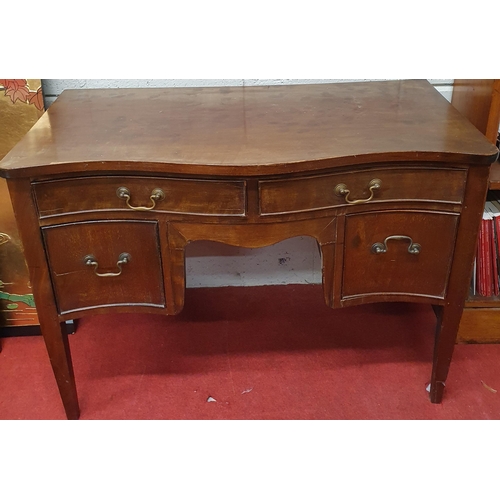 427 - A late 19th Century Mahogany serpentine Writing Desk, a shaped top over two short drawers and a knee... 