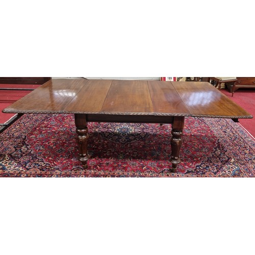 855 - A 19th Century Mahogany three leaf Dining Table with roped moulded edge on a carved tulip bulbous su... 