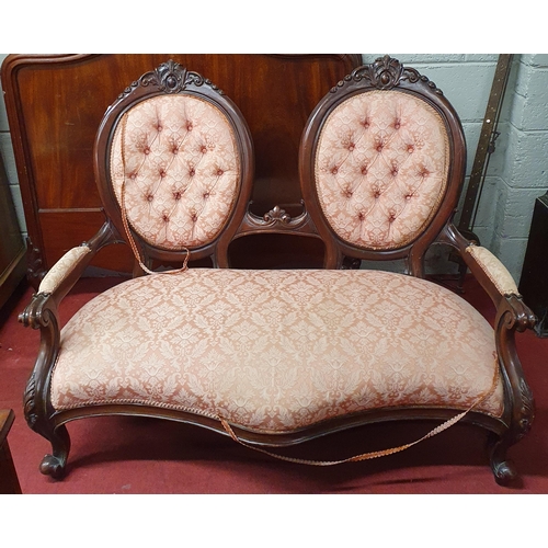 231 - A reproduction Mahogany twin panelled Love Seat with pink damask deep buttoned upholstery on carved ... 