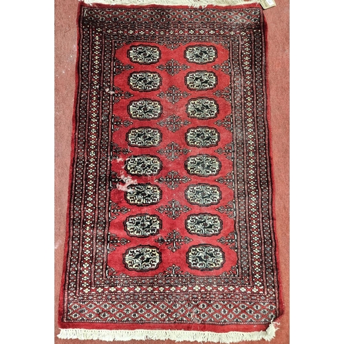 1111 - A Red ground Rug with some wear. L 132 x W 79 cm approx.