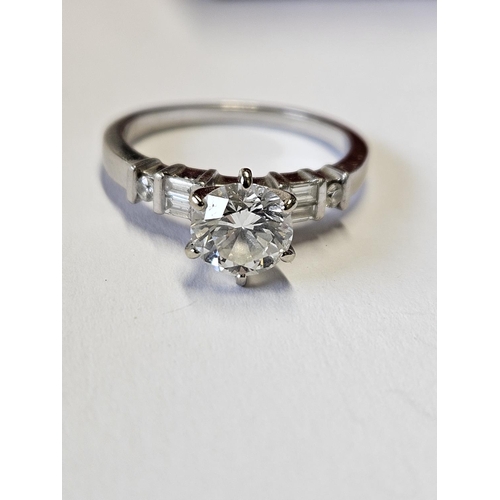 371 - A Platinum Solitaire Ring, the brilliant cut Diamond flanked by four baguette Diamonds Colour G, Cla... 