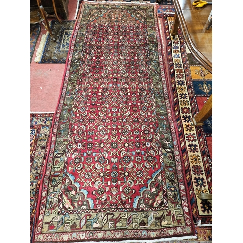 923 - A rich Red ground full pile hand woven Persian Runner with a unique all over pattern. 306 x 118 cm a... 