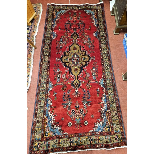 992 - A rich Red ground Persian Hamadan village  Runner with a central medallion design. 260 x 121 cm appr... 