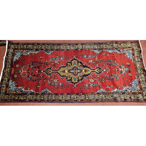 992 - A rich Red ground Persian Hamadan village  Runner with a central medallion design. 260 x 121 cm appr... 