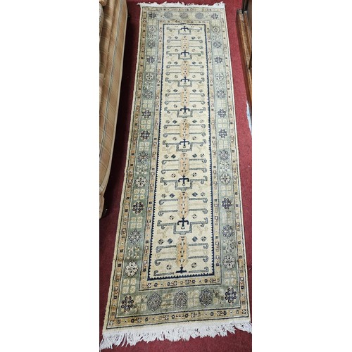 570 - A cream ground Runner with multi borders and repeating pattern central design. 235 x 69 cm approx.