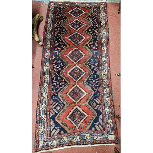 576 - A washed red and green ground Mishkin Runner with a diamond medallion design. 235 x 110cm approx.