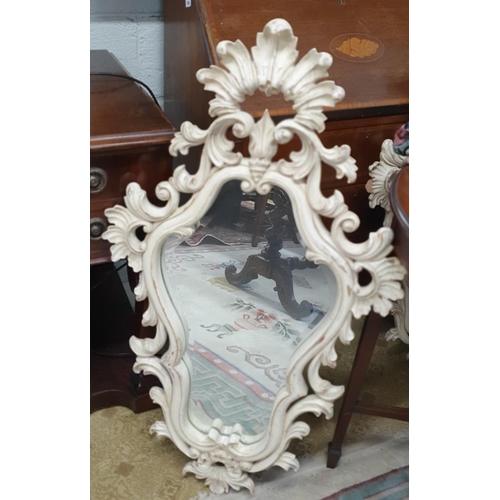 769 - A good cream painted Mirror with bevelled glass and highly ornate outline. 99 x 58 cm approx.