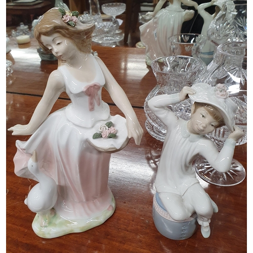 864 - A Lladro Figure of a young boy along with a Spanish figure of a girl feeding geese.