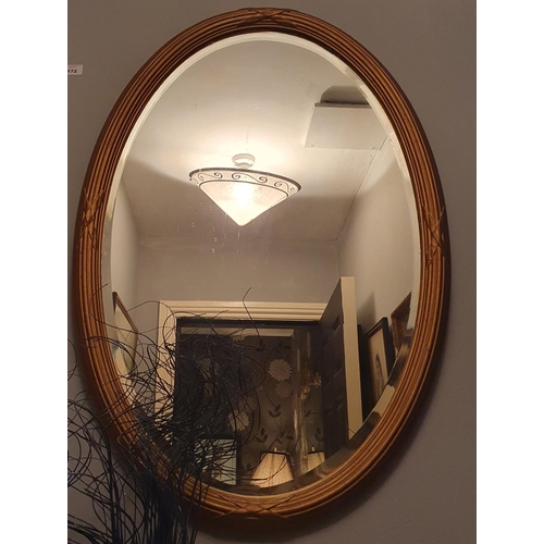 172 - An early 20th Century oval Mirror with reeded outline and bevelled mirror glass. 80 x 54 cm approx.