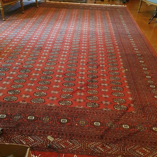 90 - A large Iranian red ground Carpet with multi borders and repeating medallion central design. 319 x 4... 