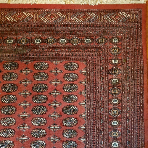 90 - A large Iranian red ground Carpet with multi borders and repeating medallion central design. 319 x 4... 