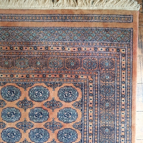 333 - A large rust ground Persian Carpet with multi borders and repeating medallion design. 195 x 305 cm a... 