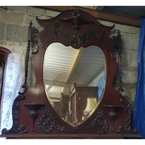 830 - An Edwardian Mahogany Overmantel Mirror with bevelled mirror glass and highly carved outline. 
W 148... 