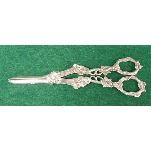 946 - A good London Silver grape Scissors with a highly variegated handle.