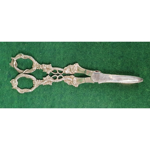 946 - A good London Silver grape Scissors with a highly variegated handle.