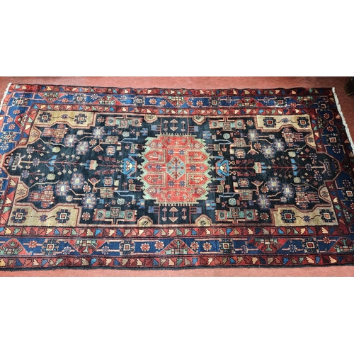 927 - A deep ground Persian Navan Carpet with a bespoke medallion design. 290 x 16 cm approx.