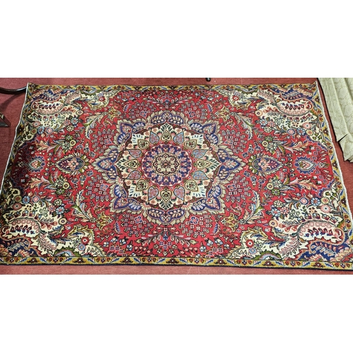 928 - A Red ground Persian Tabriz Carpet with a central lozenge medallion design and a multi coloured fiel... 