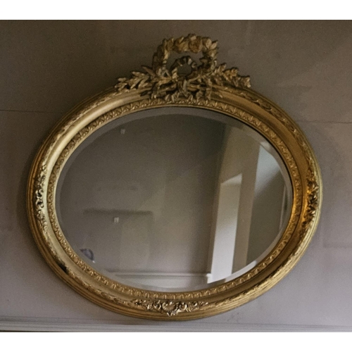 1041 - A good Timber and plaster gilt oval Mirror with cartouche top and bevelled mirror glass.
H 69 x  85 ... 