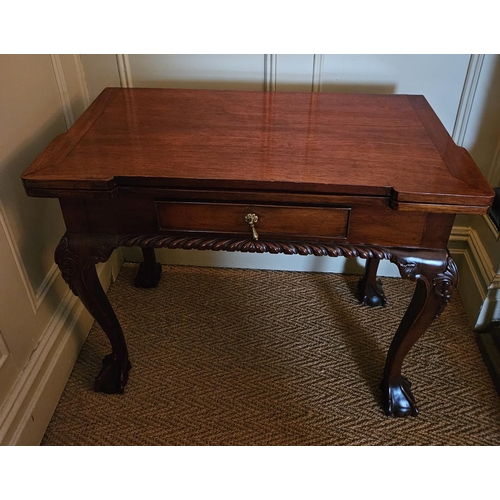 874 - A reproduction Mahogany foldover Games Table with single frieze drawer on carved cabriole ball and c... 