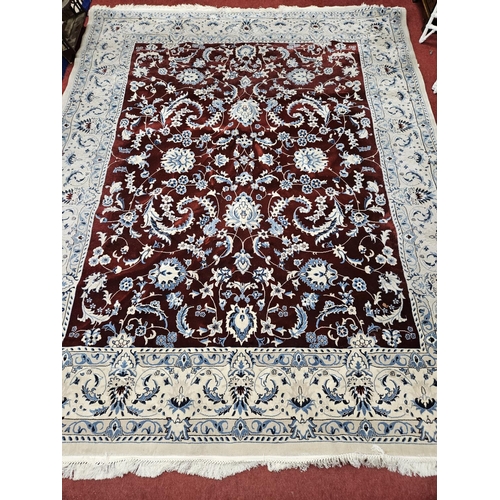 560 - A cream and burgundy ground Carpet with multi borders and repeating medallion design. 300 x 250 cm a... 