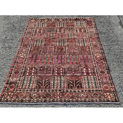 1048 - A hand woven Persian Bakhtiari Carpet with a traditional panel design, 295 x 200 cm approx