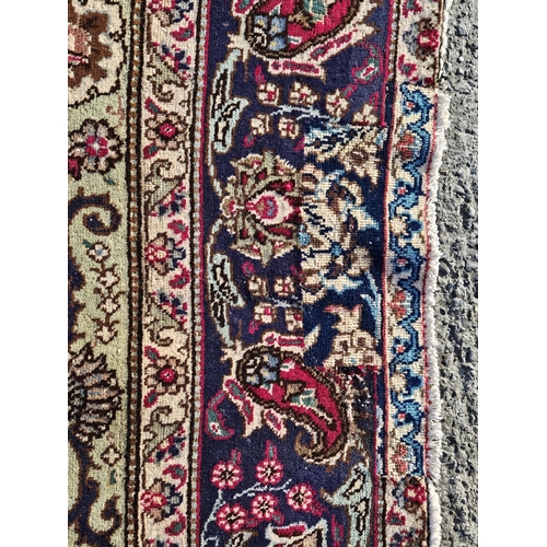 864 - A fine hand woven Persian Tabriz Carpet with a multi coloured central floral medallion design, 315 x... 