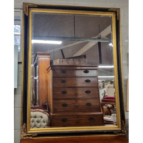 895 - A reproduction Ebonised and Timber Gilt rectangular Mirror with bevelled mirror glass and moulded co... 