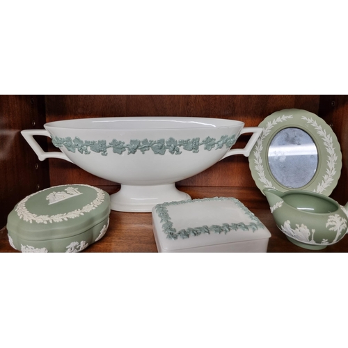 931 - A large quantity of Wedgwood green Jasperware on three shelves along with other items.