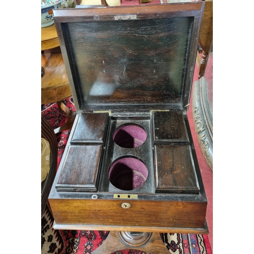 977 - A Regency Rosewood Teapoy of sarcophagus form with fitted interior on platform base. (lacking glass ... 