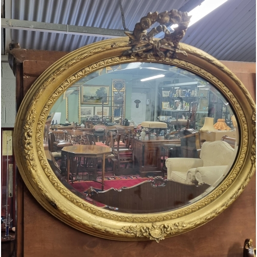 1041 - A good Timber and plaster gilt oval Mirror with cartouche top and bevelled mirror glass.
H 69 x  85 ... 