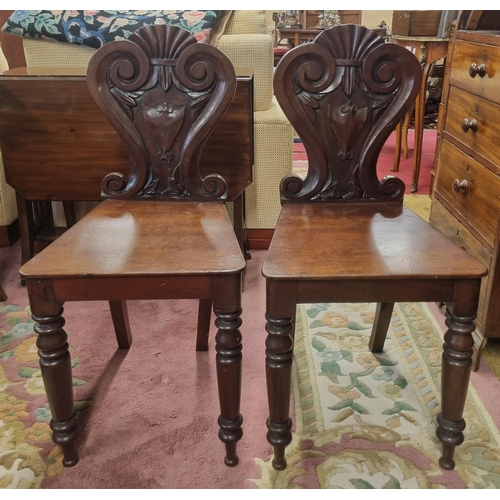 803 - A good pair of William 1Vth Mahogany Hall Chairs with highly carved backs and turned front supports.