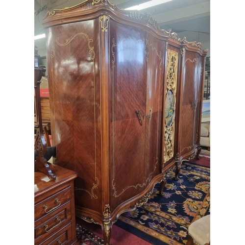 1043 - An extremely large four door serpentine fronted Wardrobe with highly painted and moulded center pane... 