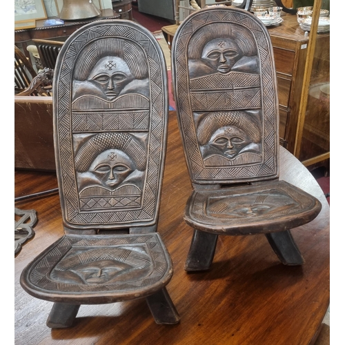 592 - An unusual pair of African fold up Seats with a highly carved outline.