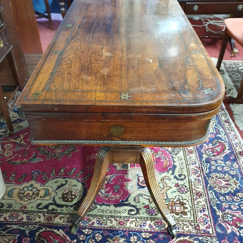 1118 - A fantastic early Regency Rosewood and brass inlaid fold over Card Table on turned reeded supports a... 