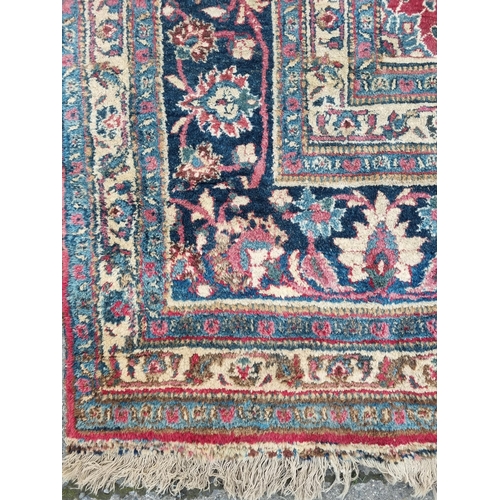 1277 - A large well worn Persian Burgundy ground Carpet with unique medallion design, 410 x 260 cm approx.