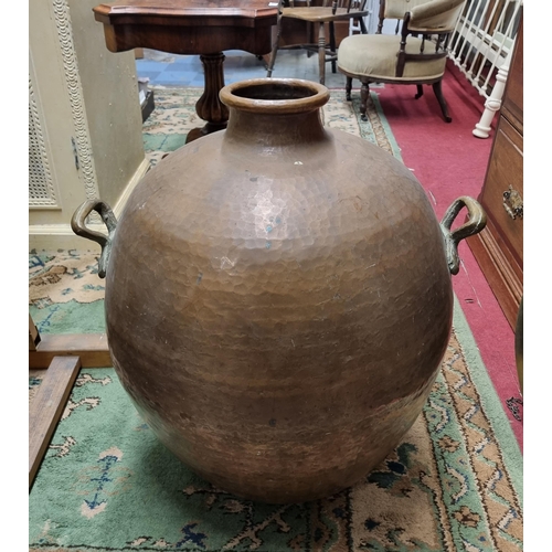 167 - An extremely large Copper bulbous Urn with panel beaten outline and twin lifting handles. H 71 cm ap... 