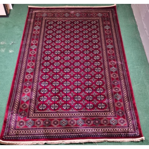 600A - A red ground Turkish Soft Full Pile Carpet with central repeated panel design surrounded by borders ... 