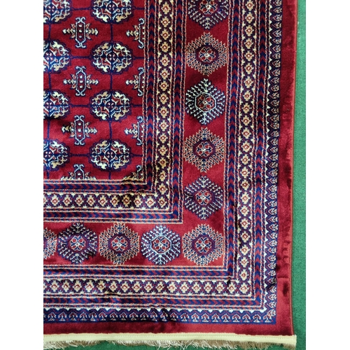 600A - A red ground Turkish Soft Full Pile Carpet with central repeated panel design surrounded by borders ... 